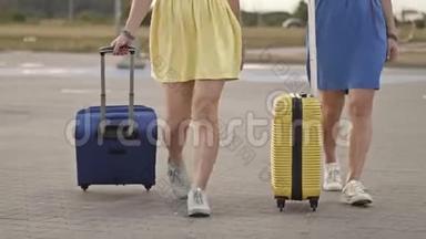 旅客携带行李箱在火车站站台行走.. 两个拿着行李的女人去机场